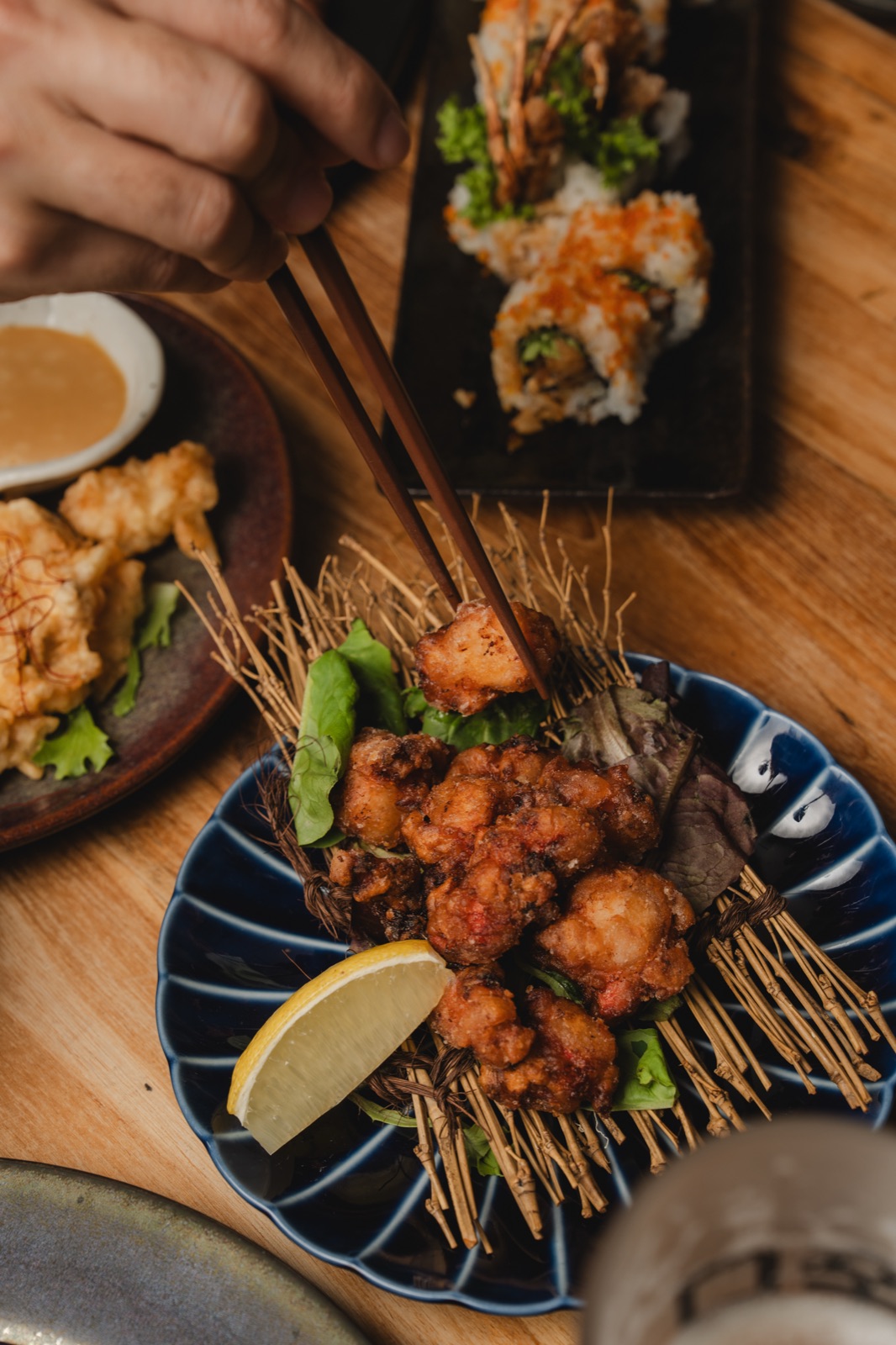 A dish of karaage being plated at Sake Zen