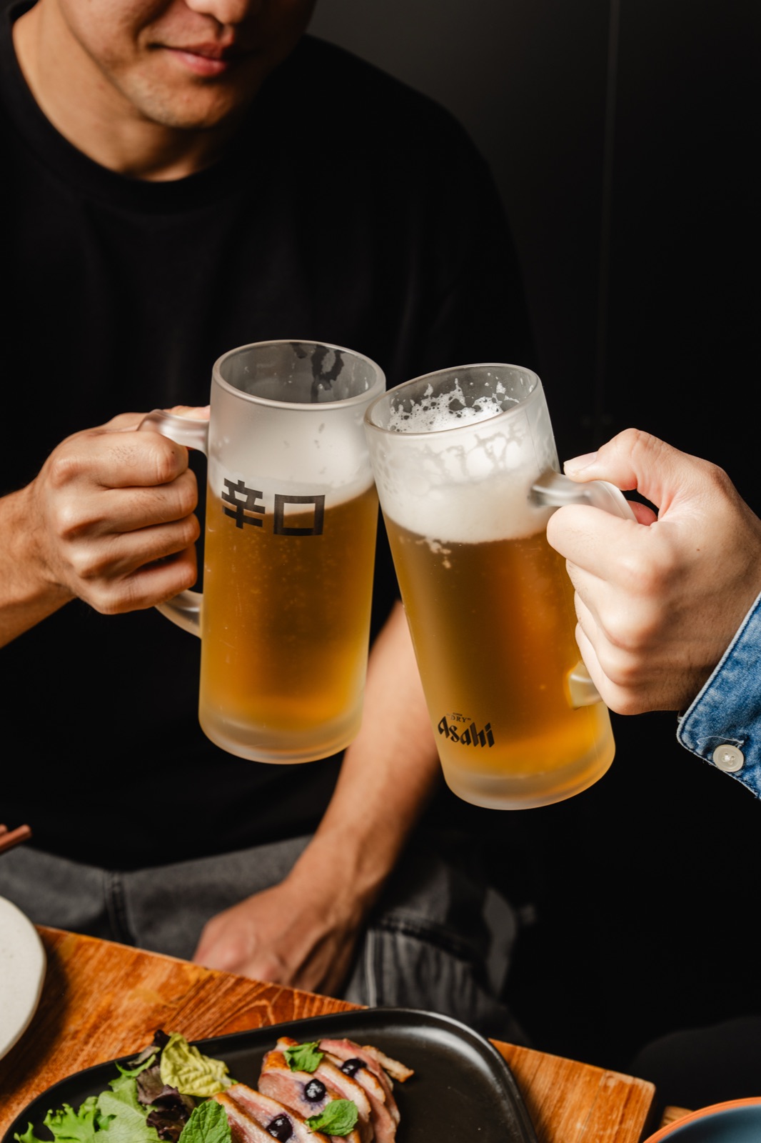 Two frosted beers raised for a cheers